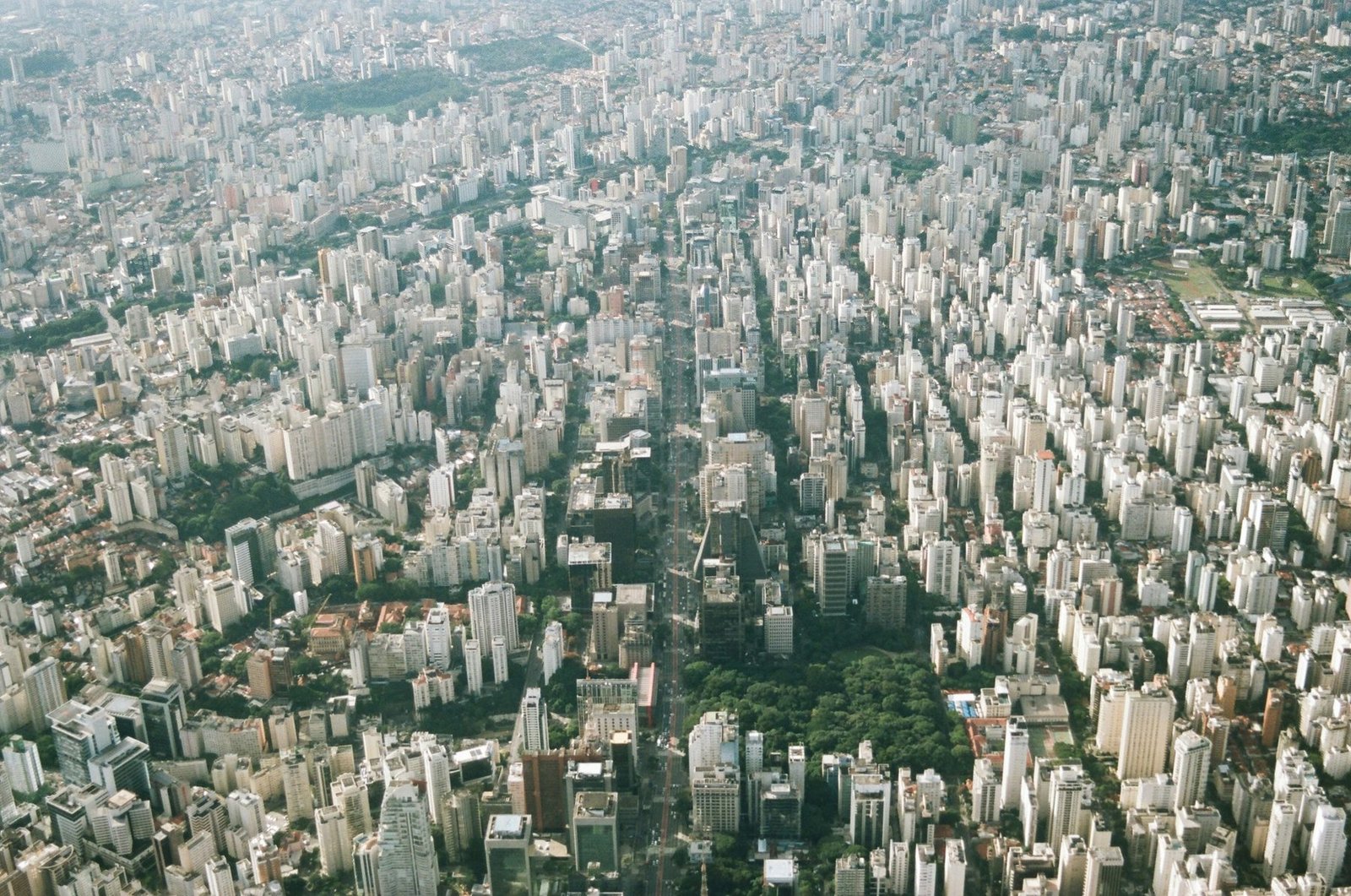 Thousands of pale towers and patches of trees stretch to the edge of the frame in a hazy aerial view