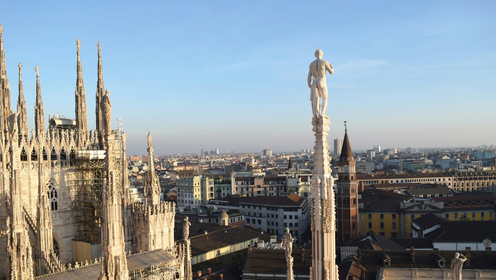 Carved marble spires topped with statues rise above rooftops stretching to the horizon