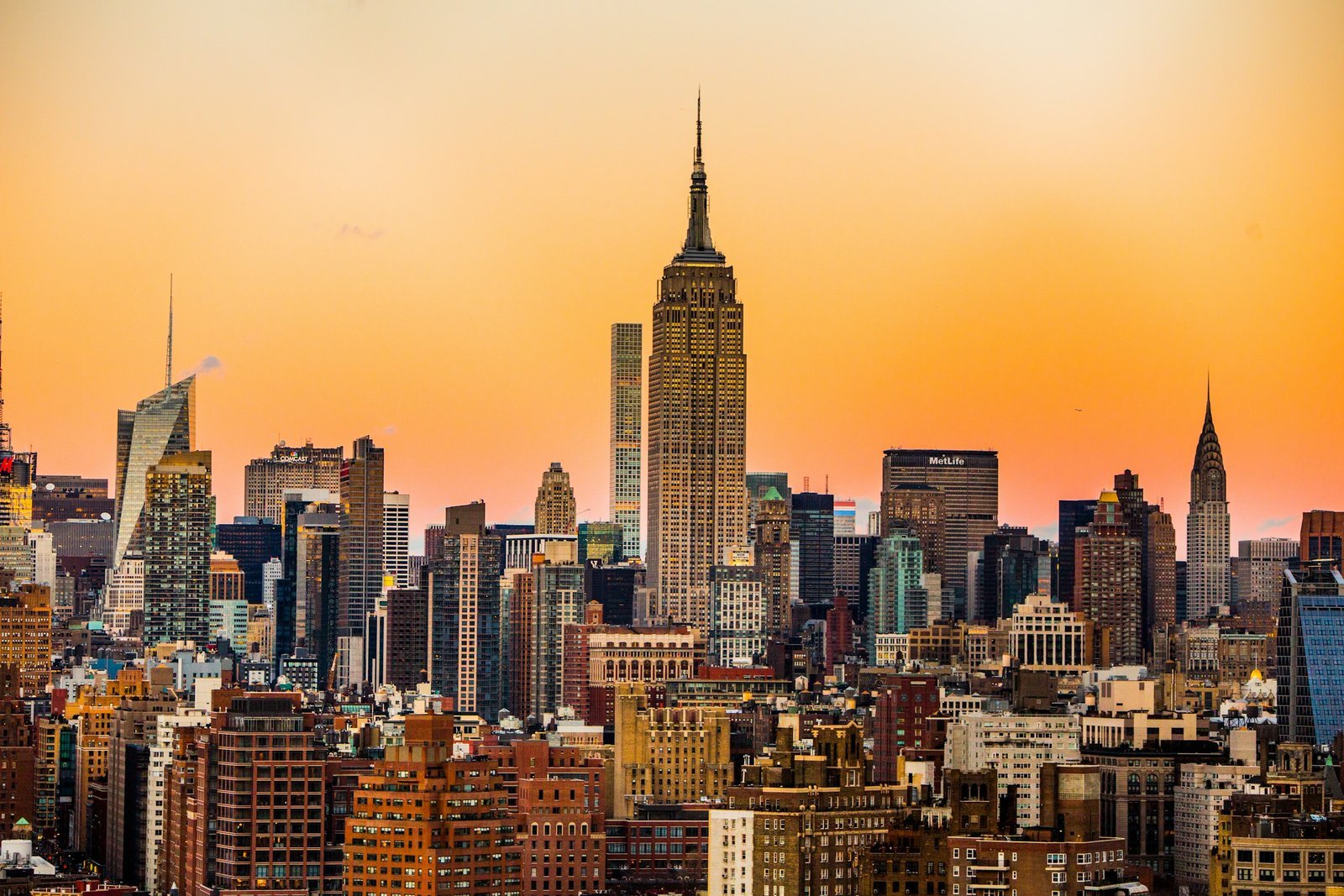 The Empire State Building at sunset over low rooftops